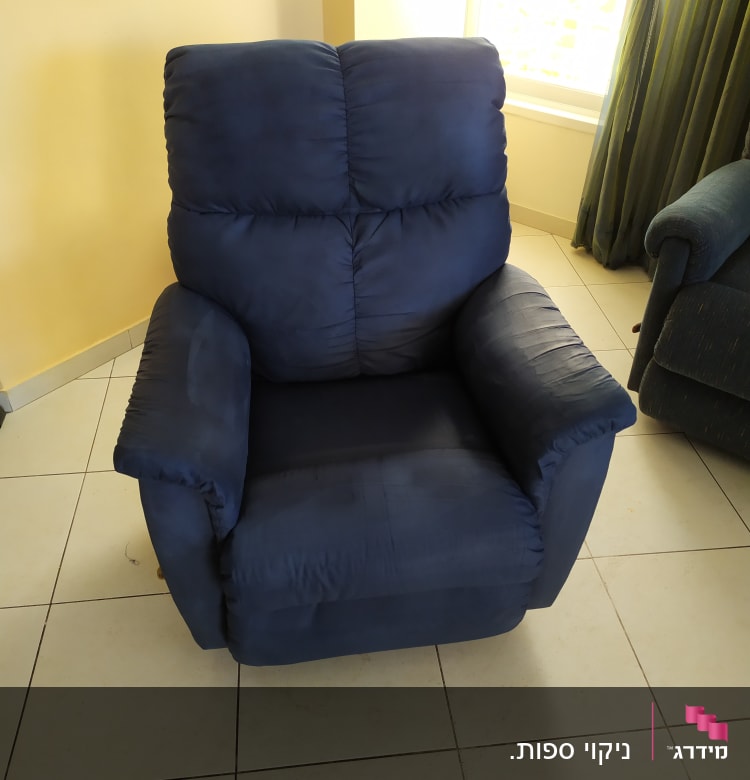 כורסה כחולה על רצפת אריחים בהירה